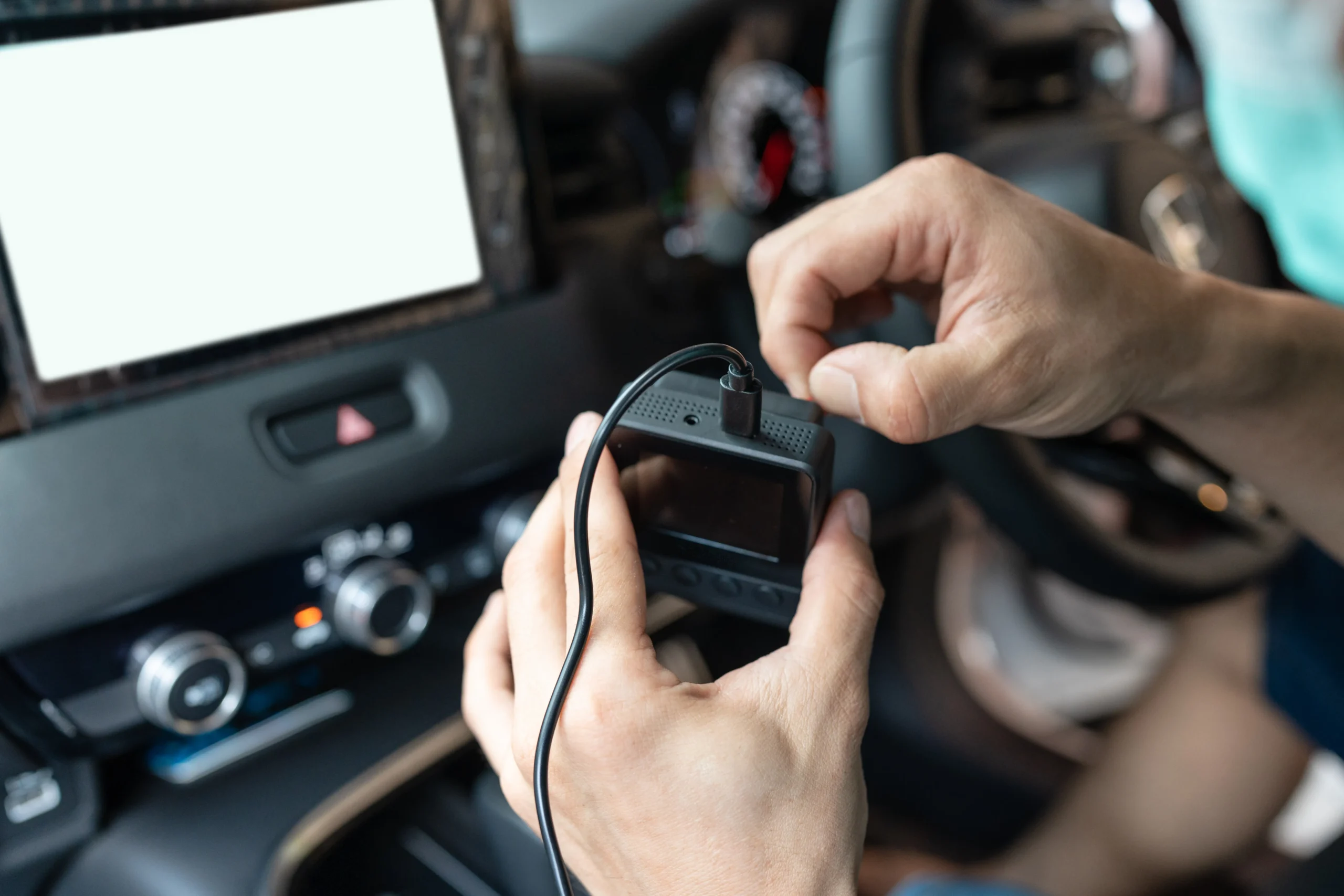 Technician preparing diagnostic tool to read vehicle fault codes inside a car