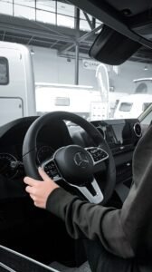 a person sitting in a car with a steering wheel