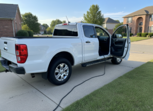 White Ford Ranger pickup connected to an OBD cable for diesel fault diagnosis
