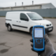 Gloved hand connecting a blue OBD scanner to a Peugeot van for AdBlue fault diagnosis
