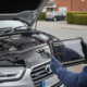 Mechanic holding diagnostic tablet beside an Audi TDI diesel vehicle