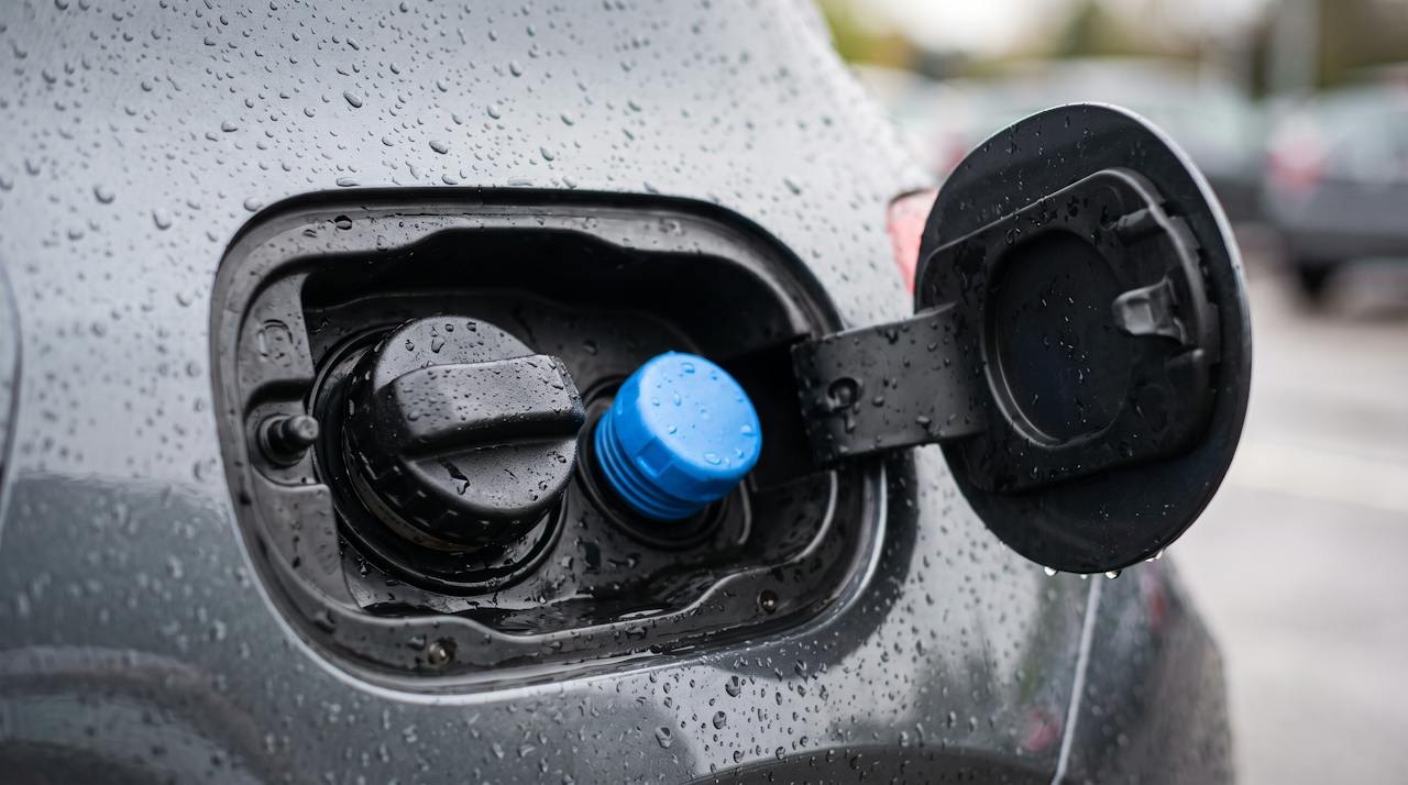 Open fuel flap showing the diesel cap and the blue AdBlue (DEF) filler cap